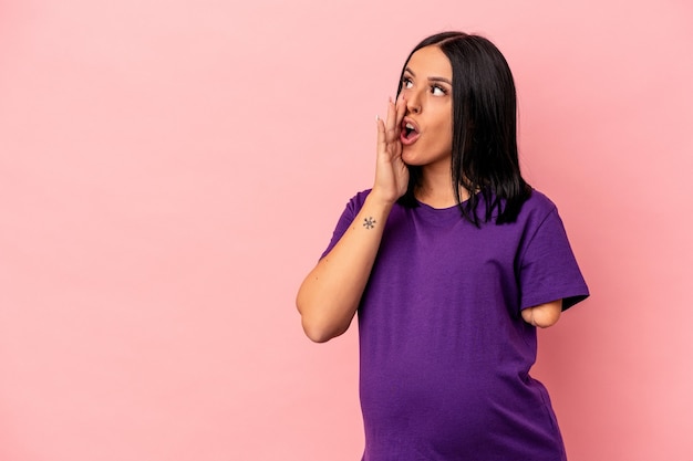 Młoda kobieta w ciąży z jedną ręką odizolowaną na różowym tle mówi sekretne gorące wiadomości o hamowaniu i odwraca wzrok