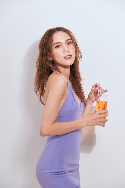 Młoda kobieta w fioletowej sukience picia koktajlu
