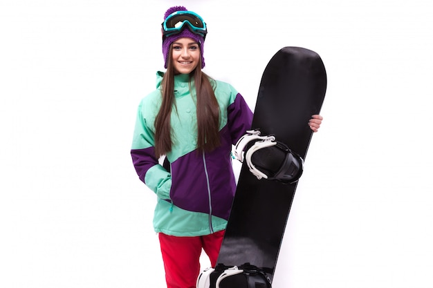 Młoda kobieta w fioletowy strój narciarski trzymać snowboard