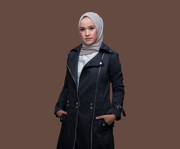 Zdjęcie młoda kobieta w hidżabie, ubrana w czarny płaszcz z chłodnym wyrazem twarzy