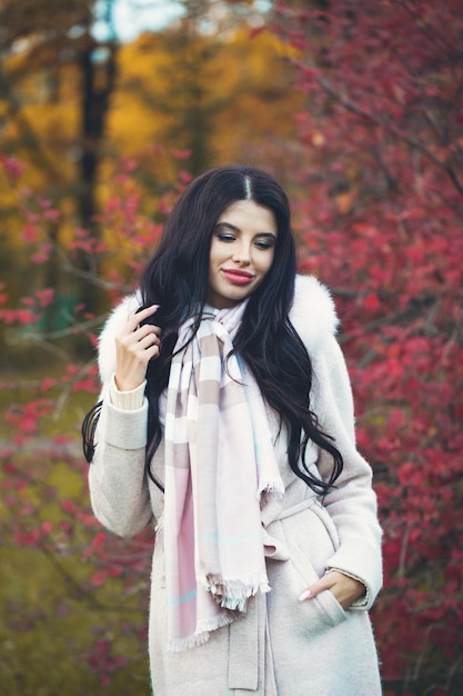 Młoda kobieta w jesiennym płaszczu na jesiennym parkowym tle portret na zewnątrz