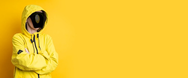 Młoda kobieta w masce cyberpunkowych gogli w żółtej kurtce w kapturze na żółtym tle Banner