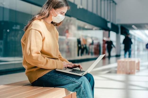 Młoda kobieta w masce ochronnej na ulicy miasta. epidemia w mieście