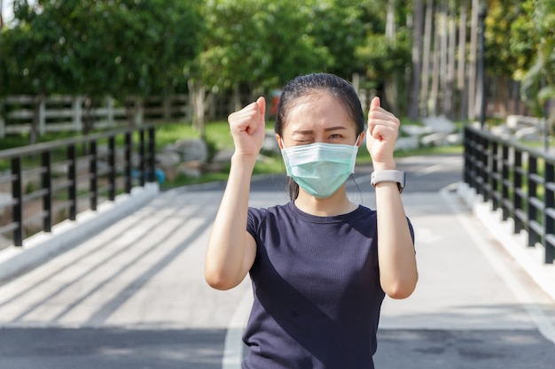 Młoda kobieta w medycznej masce ochronnej relaks w parku. kampania użycia maski ochronnej od COVID19