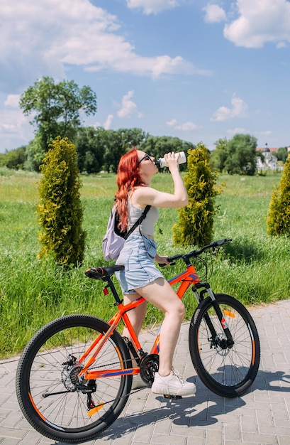 Zdjęcie młoda kobieta w mieście jeździ na rowerze i prowadzi aktywny styl życia, uprawiając sport