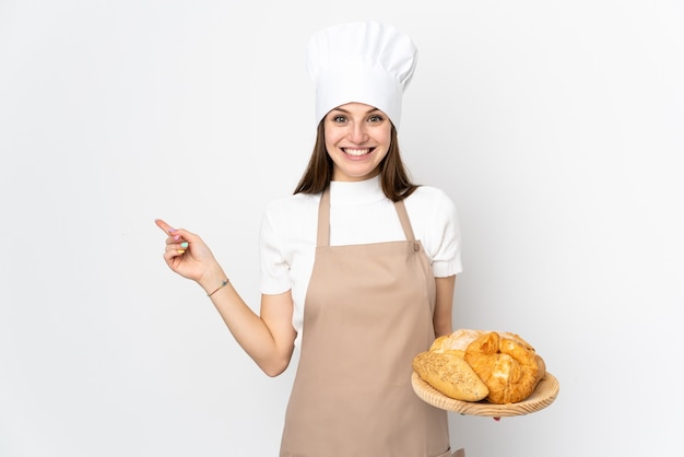 Młoda kobieta w mundurze szefa kuchni na biały palec wskazujący na bok