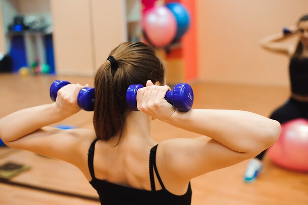 Młoda kobieta w odzieży sportowej, robienie ćwiczeń fitness z fit ball