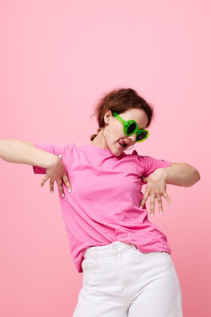 Młoda kobieta w różowym Tshirt zielonych okularach Moda młodzieżowa na białym tle