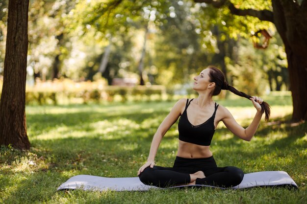 młoda kobieta w sportowym mundurze relaksuje się i medytuje w miejskim parku
