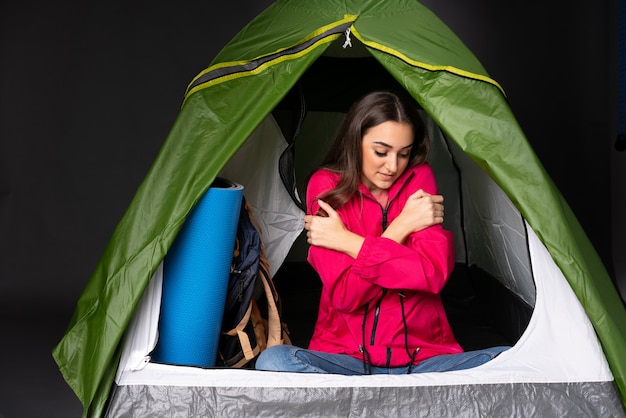 Młoda kobieta w środku camping zielony namiot zamrażania