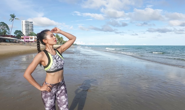 młoda kobieta w stroju sportowym, ćwiczenia na plaży