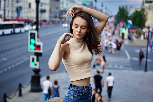 Młoda kobieta w uprawnej koszulce bez rękawów na Newskim Prospekcie w rosyjskim mieście st petersburg na lato