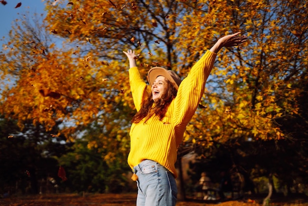 Młoda kobieta w żółtym swetrze i dżinsach odpoczywająca w naturze koncepcja stylu mody styl życia ludzi