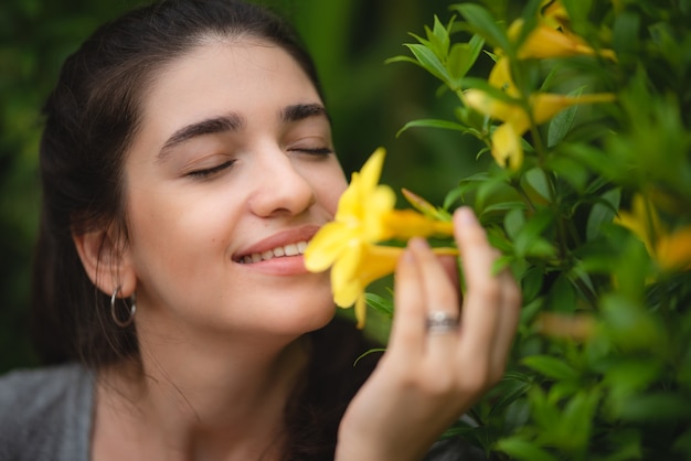 Młoda kobieta wącha żółte kwiaty