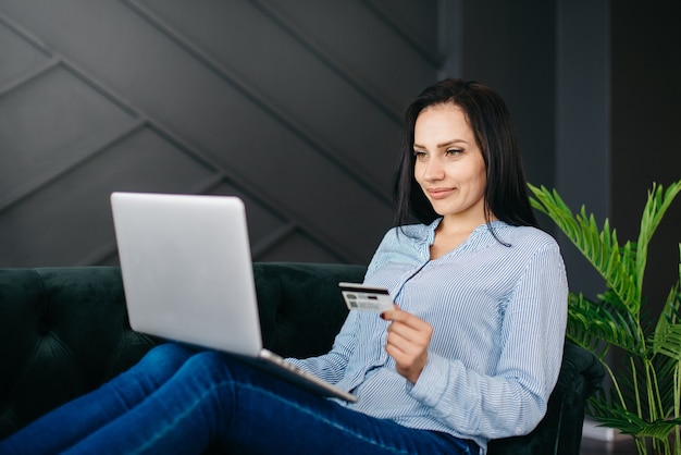 Młoda kobieta wprowadza dane karty kredytowej na laptopie w celu płatności online