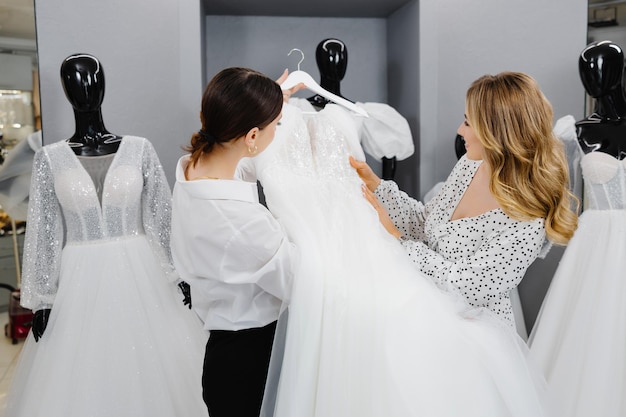 Młoda kobieta wybierająca sukienkę ślubną w salonie Panna młoda przyszła do salonu sukienek ślubnych, by kupić sukienkę.