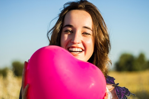 Młoda kobieta z balonem na polu pszenicy