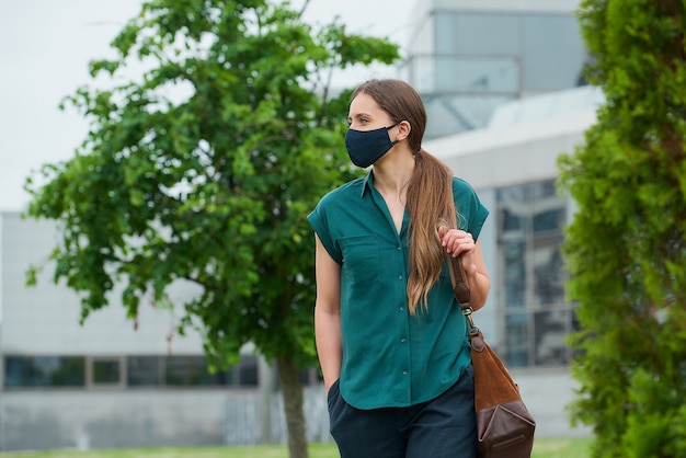 Młoda kobieta z czarną maską w mieście