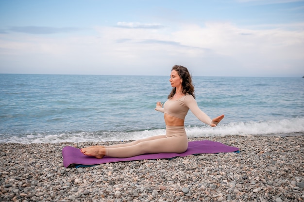 Młoda kobieta z czarnymi włosami instruktorka fitness w legginsach i bluzkach robi rozciąganie i pilates na