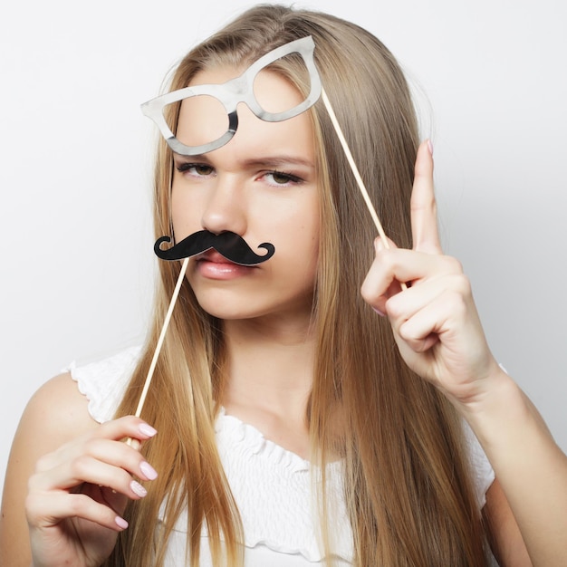 Młoda kobieta z fałszywymi wąsami gotowa na imprezę