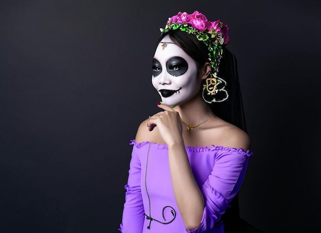 młoda kobieta z gotyckim wampirzym makijażem na imprezie Halloween na czarnym tle