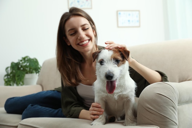 Młoda kobieta z jej cute Jack Russell Terrier na kanapie w domu Lovely pet