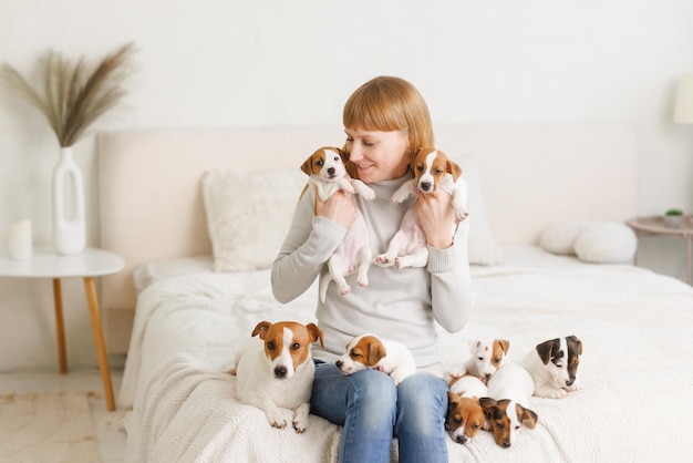 Młoda kobieta z jej ślicznym Jack Russell Terrierem w krześle w domu białym zwierzaku