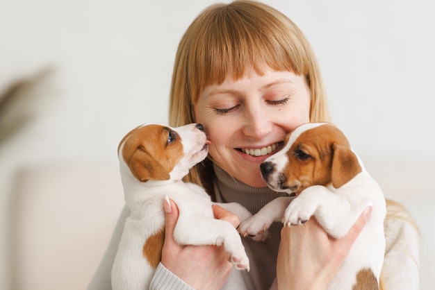 Młoda kobieta z jej ślicznym Jack Russell Terrierem w krześle w domu białym zwierzaku