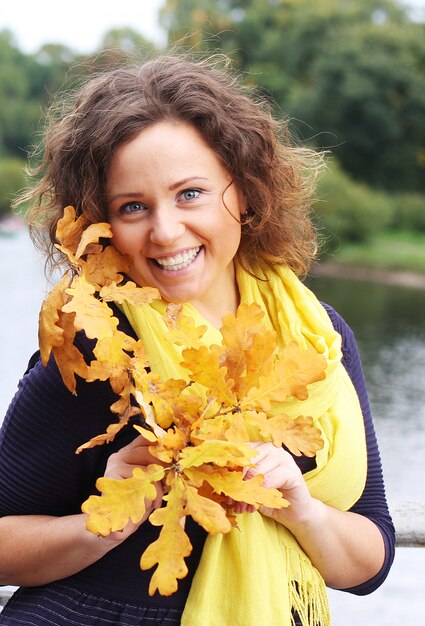 Młoda kobieta z jesień liśćmi w parku