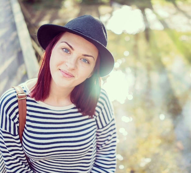 Młoda kobieta z kapeluszem ma zabawę w naturze na rzece