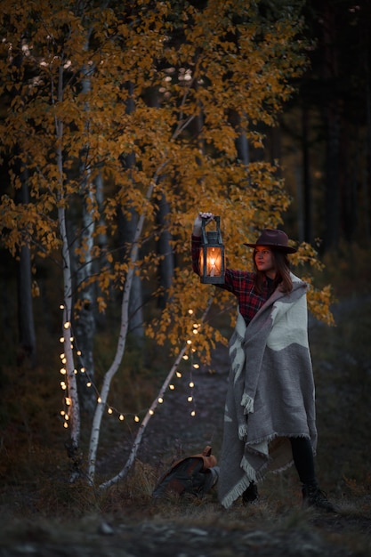 Zdjęcie młoda kobieta z nafty lampą w lesie