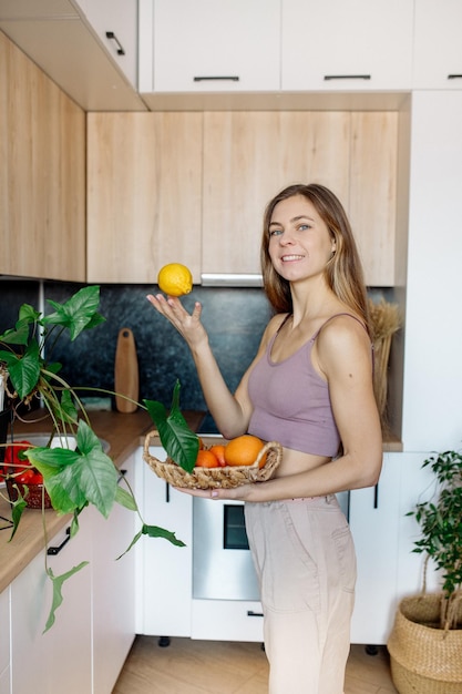 Młoda kobieta z owocami w kuchni Zdrowe wegańskie jedzenie w domu