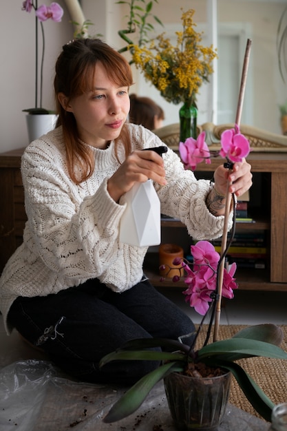 Zdjęcie młoda kobieta z piękną orchideą w pełnym ujęciu