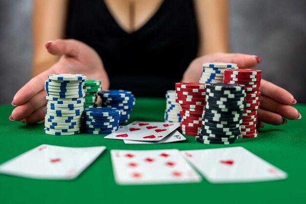 Młoda kobieta z powodzeniem uprawia hazard w kasynie przy stole z żetonami i alkoholem