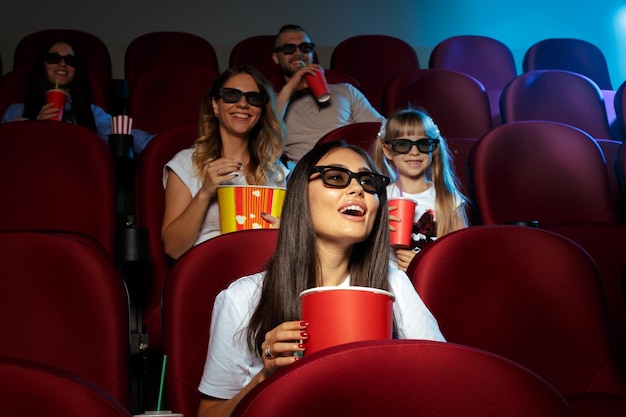 Młoda kobieta z przyjaciółmi ogląda film w kinie