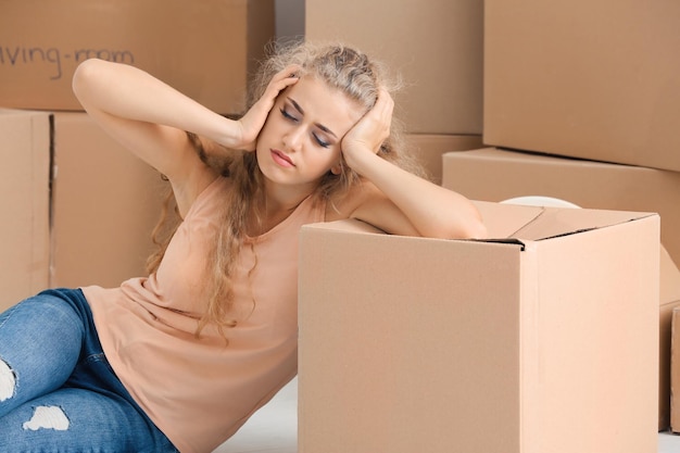 Zdjęcie młoda kobieta z ruchomymi pudełkami na podłodze w pokoju