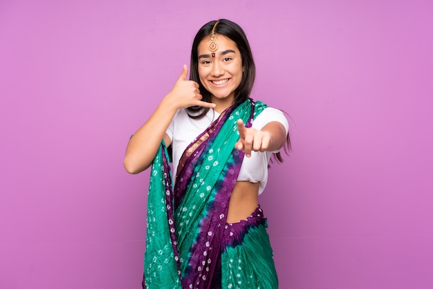 Młoda kobieta z sari nad gestem telefonu i wskazując przód