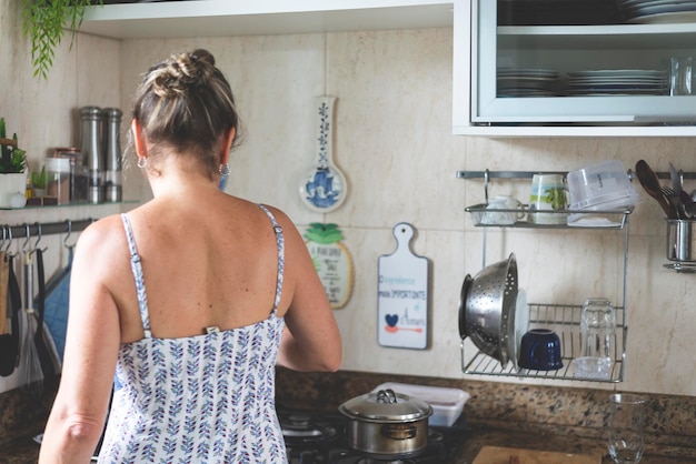 Zdjęcie młoda kobieta z tyłu przygotowująca jedzenie w kuchni