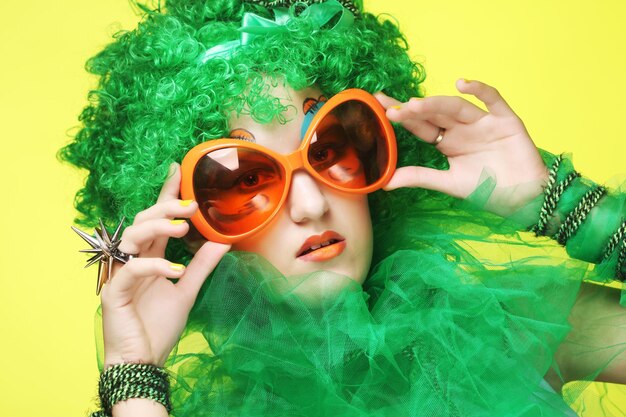 Młoda kobieta z zielonymi włosami i okularami karnawałowymi