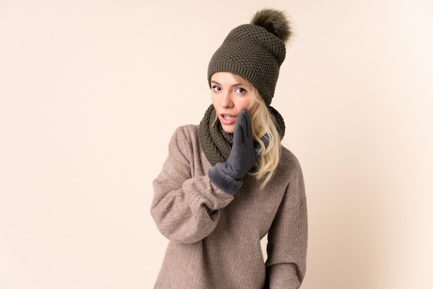 Młoda kobieta z zima kapeluszem nad odosobnionym szeptać coś