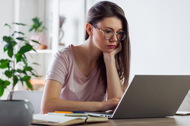 Młoda kobieta za pomocą laptopa do pracy w domu