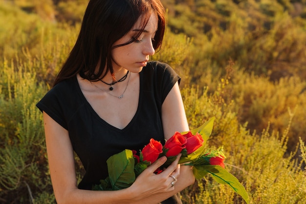 Młoda kobieta zakochana, z różami w ramionach. Walentynki