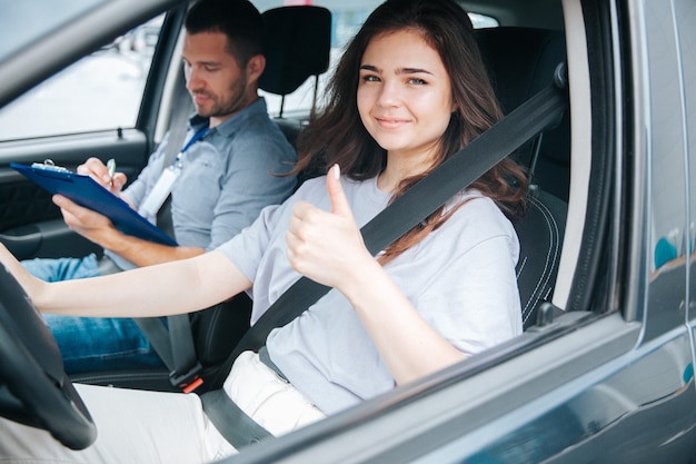 Młoda kobieta ze swoim instruktorem auto w samochodzie