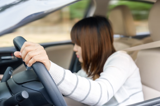 Młoda kobieta znaleźć coś w przedniej szufladzie samochodu z nieostrożnością podczas jazdy - accide