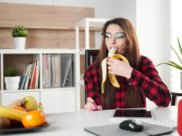 Młoda kobieta zrób sobie przerwę i zjedz owoc banana