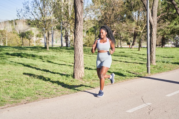 Zdjęcie młoda, krągła kobieta trenuje bieganie afroamerykanki
