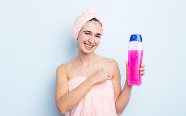 Młoda ładna kobieta czuje się szczęśliwa i staje przed wyzwaniem lub świętuje. koncepcja prysznica i szamponu