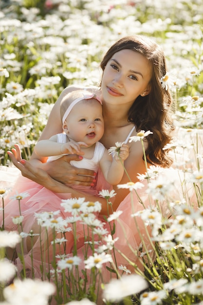 Młoda ładna matka z jej małym dzieckiem na zewnątrz. Piękna kobieta z jej córką na naturze. niemowlę dziecko z rodzicem na polu rumianku