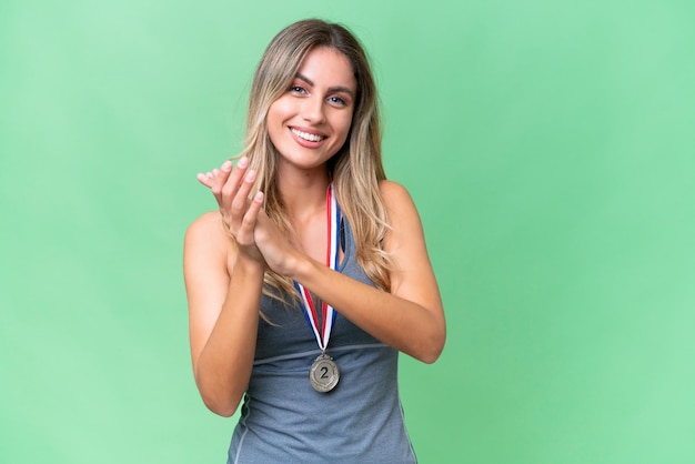 Młoda ładna sportowa Urugwajska kobieta z medalami na odosobnionym tle bije brawo po prezentacji na konferencji