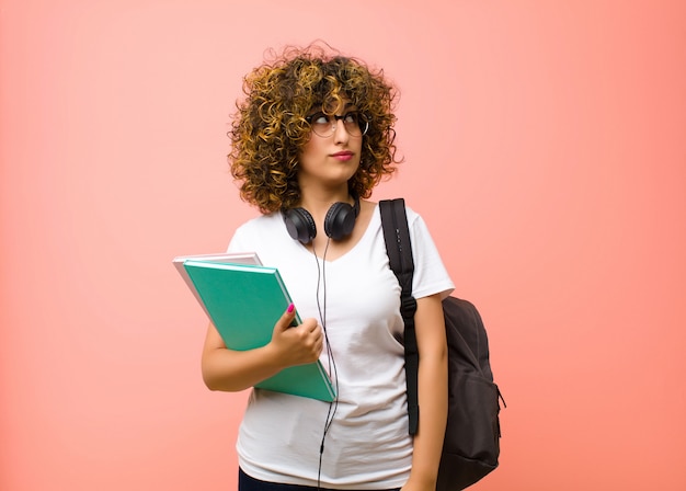 Młoda ładna Studencka Kobieta O Zmartwionym, Zdezorientowanym, Nieświadomym Wyrazie, Patrząca W Stronę Kopii Przestrzeni, Wątpiąca W Różową ścianę